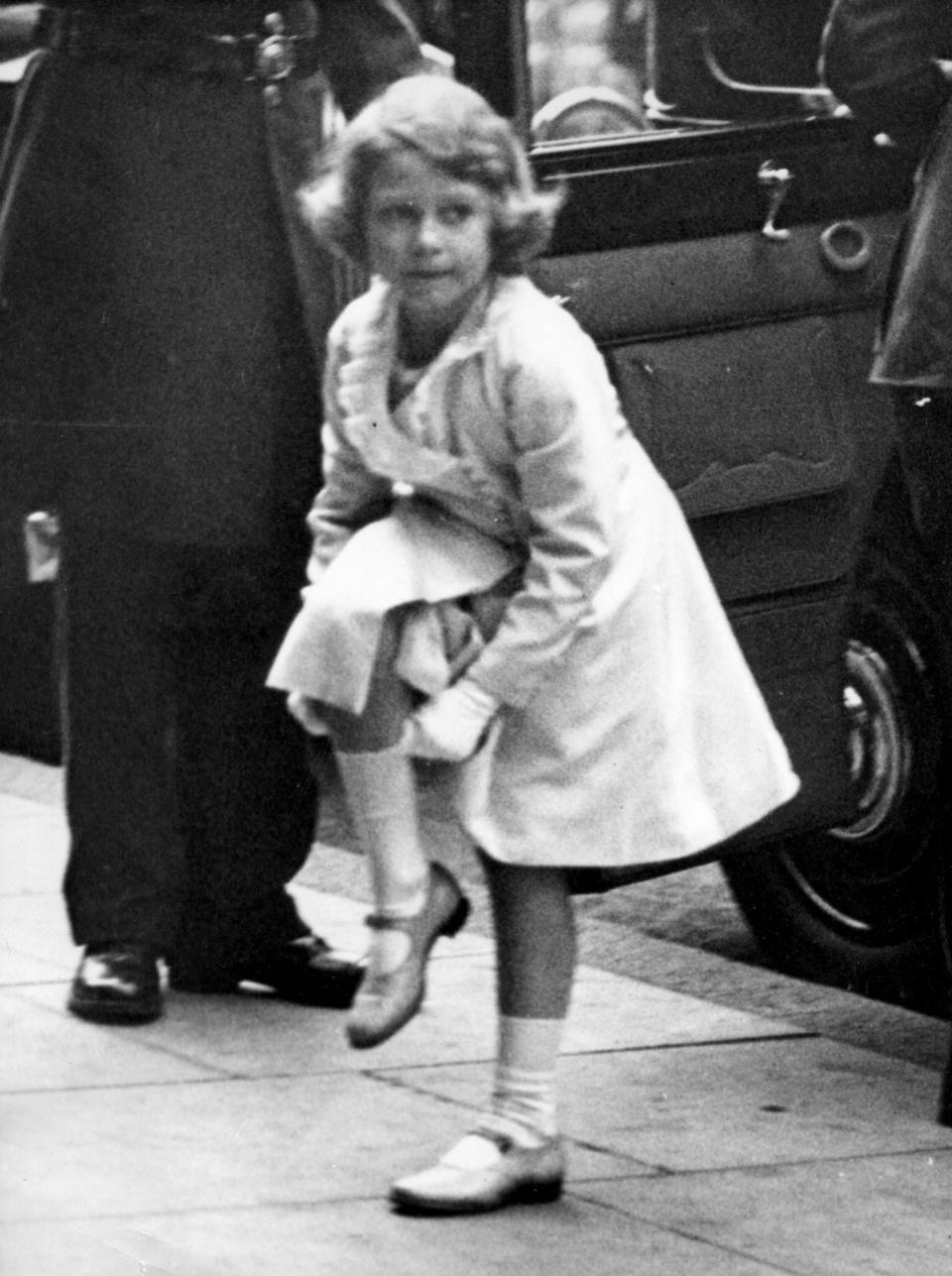 A young Queen Elizabeth pulls up her socks