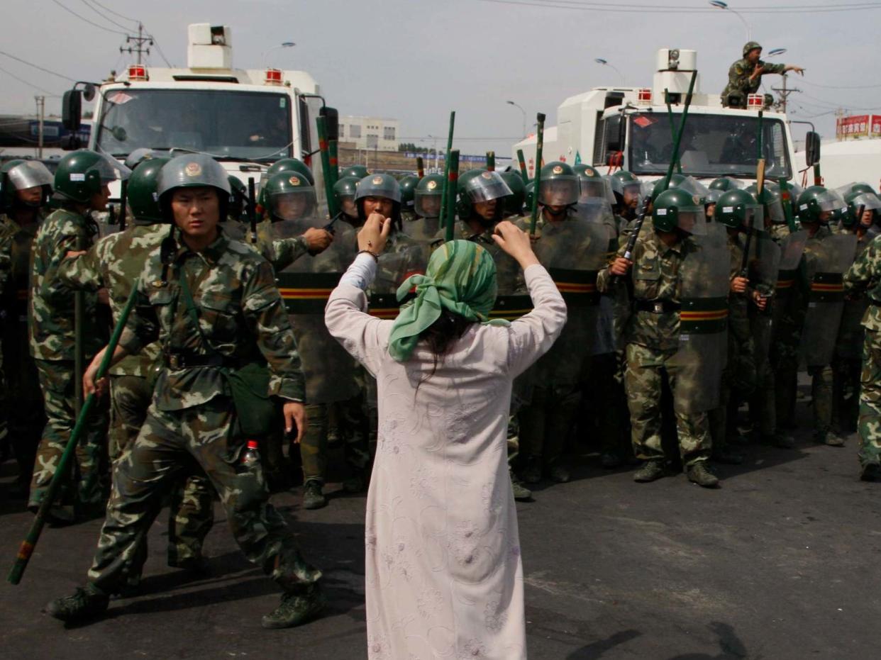 An Uighur woman protests before a group of paramilitary police when journalists visited Xinjiang in July, 2009: AP