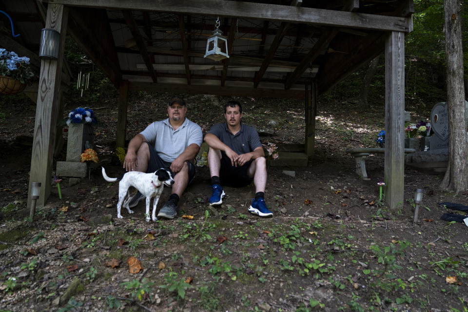 Image: Ashford White, 43, and Burley White, 28, in the family cemetery above their house, where they spent the night during the flooding that destroyed much of the River Caney community of Lost Creek on Aug. 18, 2022. (Michael Swensen for NBC News)