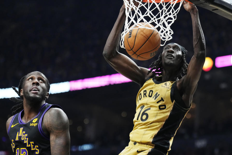 Toronto Raptors forward Mouhamadou Gueye (16) dunks next to Los Angeles Lakers forward Taurean Prince (12) during the first half of an NBA basketball game Tuesday, April 2, 2024, in Toronto. (Frank Gunn/The Canadian Press via AP)