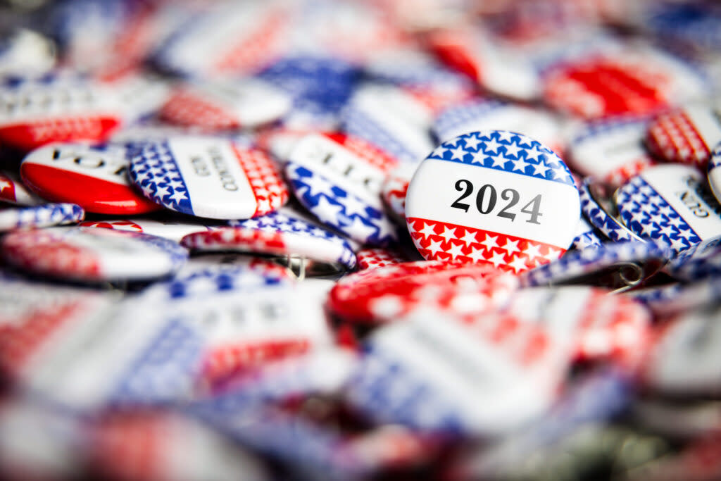 Red white and blue campaign buttons, with stars and 2024 printed on them.