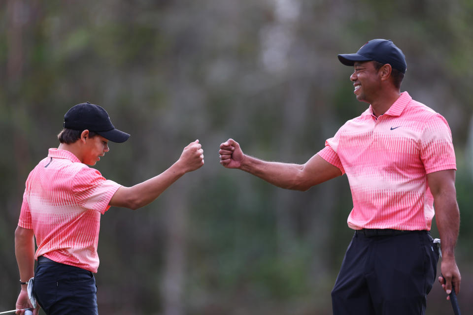 Tiger Woods and his son bumping fists during the tournament. (Mike Ehrmann / Getty Images)