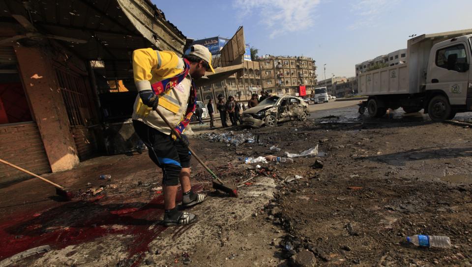 Municipality workers clean the site of a bomb attack in Baghdad, January 15, 2014. Bomb attacks hit the Iraqi capital Baghdad and a village near the northern town of Baquba on Wednesday, killing at least 52 people, police and hospital sources said. (REUTERS/Ahmed Saad)