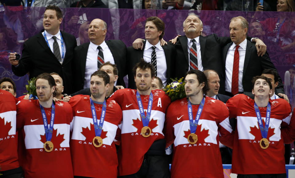 FILE - Canada players and coaches sing the national anthem after being awarded their gold medals after they beat Sweden 3-0 in the men's ice hockey gold medal game at the 2014 Winter Olympics, Sunday, Feb. 23, 2014, in Sochi, Russia. Four years after walking away with a bronze medal after the NHL did not participate, Canada's team in Beijing has remnants of the ones that won gold in 2010 and 2014 and a roster that looks capable of doing it again. (AP Photo/Mark Humphrey, File)