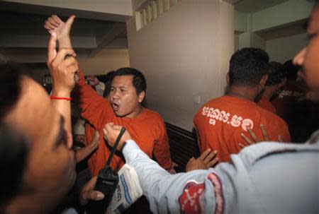 A man (C) convicted of plotting to overthrow the Cambodian government shouts after being sentenced at the Phnom Penh Municipal Court April 11, 2014. REUTERS/Samrang Pring