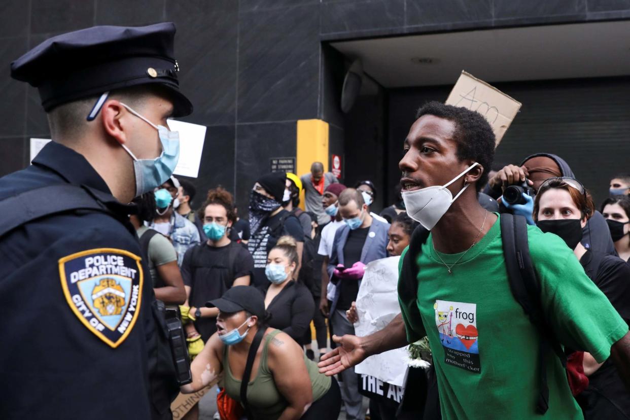 A protester confronts a police officer during an 'I can't breathe' vigil and rally in New York: REUTERS