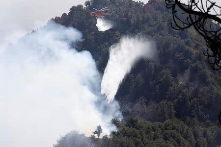 An air crane helicopter drops water while battling the Wilson Fire near Mount Wilson in the Angeles National Forest in Los Angeles, California, U.S. October 17, 2017. REUTERS/Mario Anzuoni