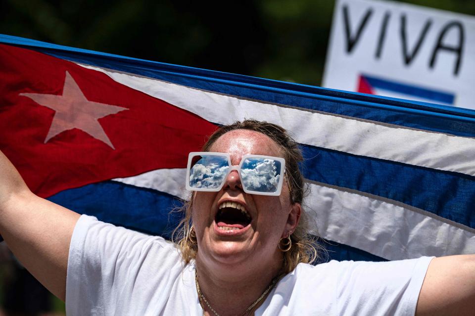 A demonstrator holds the Cuban flag while protesting in front of the White House in Washington, DC, on July 12, 2021.