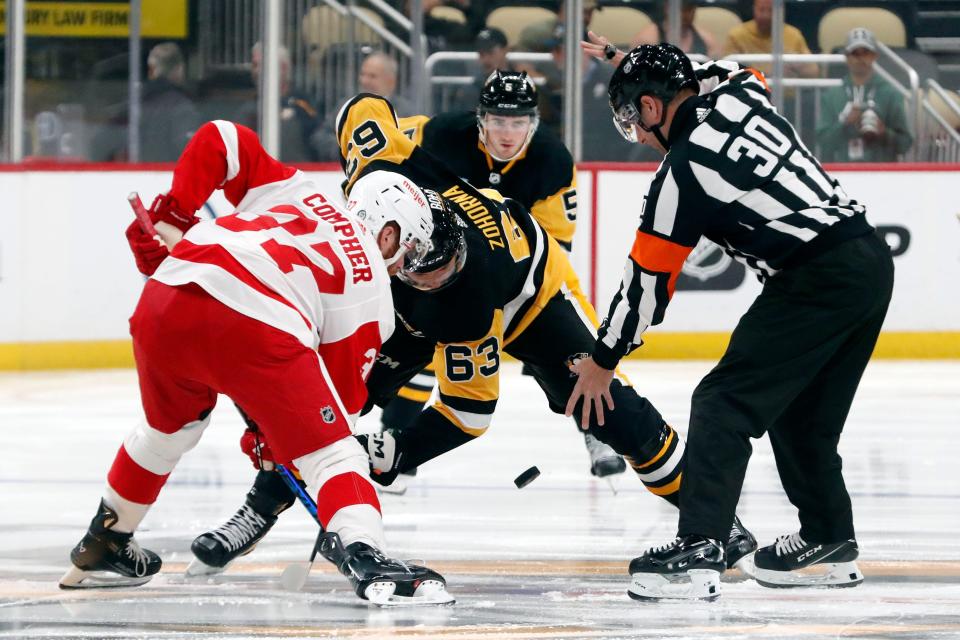 Detroit Red Wings forward J.T. Compher (37) and left wing Radim Zohorna (63) take the opening face-off during the first period at PPG Paints Arena in Pittsburgh on Wednesday, Oct. 4, 2023.