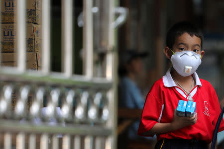 A student wears a mask as he waits to be picked up, as classes in over 400 Bangkok schools have been cancelled due to worsening air pollution, at a public school in Bangkok, Thailand, January 30, 2019. REUTERS/Athit Perawongmetha