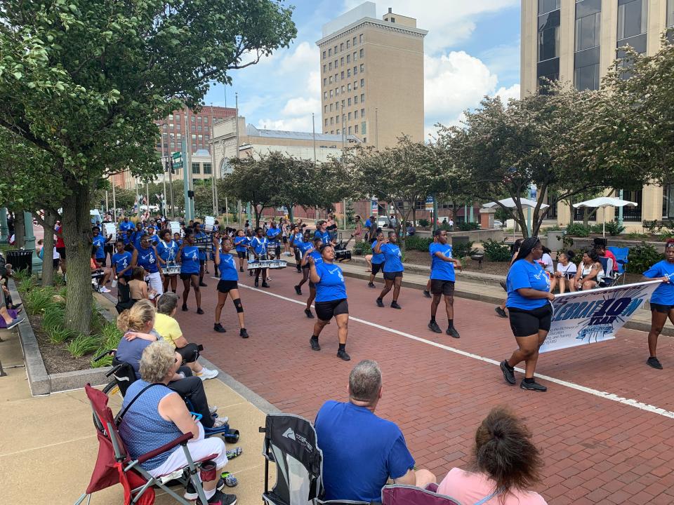 Cheerleaders and band members from EN-RICH-MENT, a fine arts nonprofit, dance Sunday at the Community Parade in downtown Canton. The event kicks off the annual Pro Football Hall of Fame Festival.