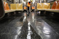 A contractor cleans a subway car at the 96th Street station to control the spread of COVID-19, Thursday, July 2, 2020, in New York. Mass transit systems around the world have taken unprecedented — and expensive — steps to curb the spread of the coronavirus, including shutting down New York subways overnight and testing powerful ultraviolet lamps to disinfect seats, poles and floors. (AP Photo/John Minchillo)