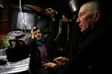 Tamara and Yuri Baikov, both 69, listen to the radio inside their hut situated in a forest near the village of Yukhovichi, Belarus, February 7, 2018. REUTERS/Vasily Fedosenko