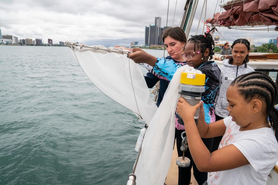 Inland Seas Crew member Meghan Wysocki, 19, of Grosse Pointe, left, demonstrates how to collect plankton to Accent Pontiac Youth Lay'Onna Dawson, 11, of Pontiac; Dynasty Smith, 11, of Pontiac, and Janae Dewberry, 12, of Pontiac, as the Inland Seas schooner sails on the Detroit River on Monday, Aug. 7, 2023. The Detroit River Skiff and Schooner program takes youths from around metro Detroit and educates them on area history, ecology, culture, and the love of sailing.