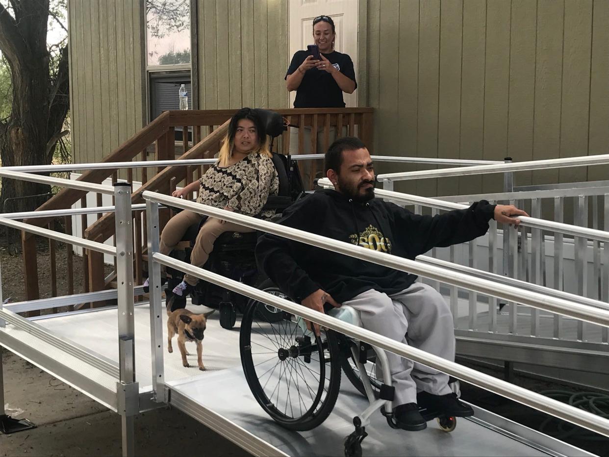 Izzy Vigil, right, rolls down the new ramp to his home for the first time, followed by Kierra Livingston, on June 20.