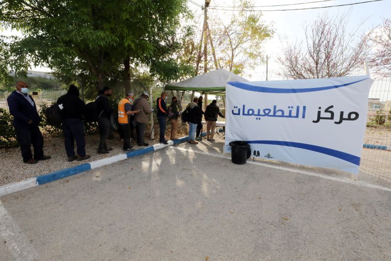 Palestinian labourers wait to be vaccinated at Shaar Efraim crossing from Israel to the West Bank