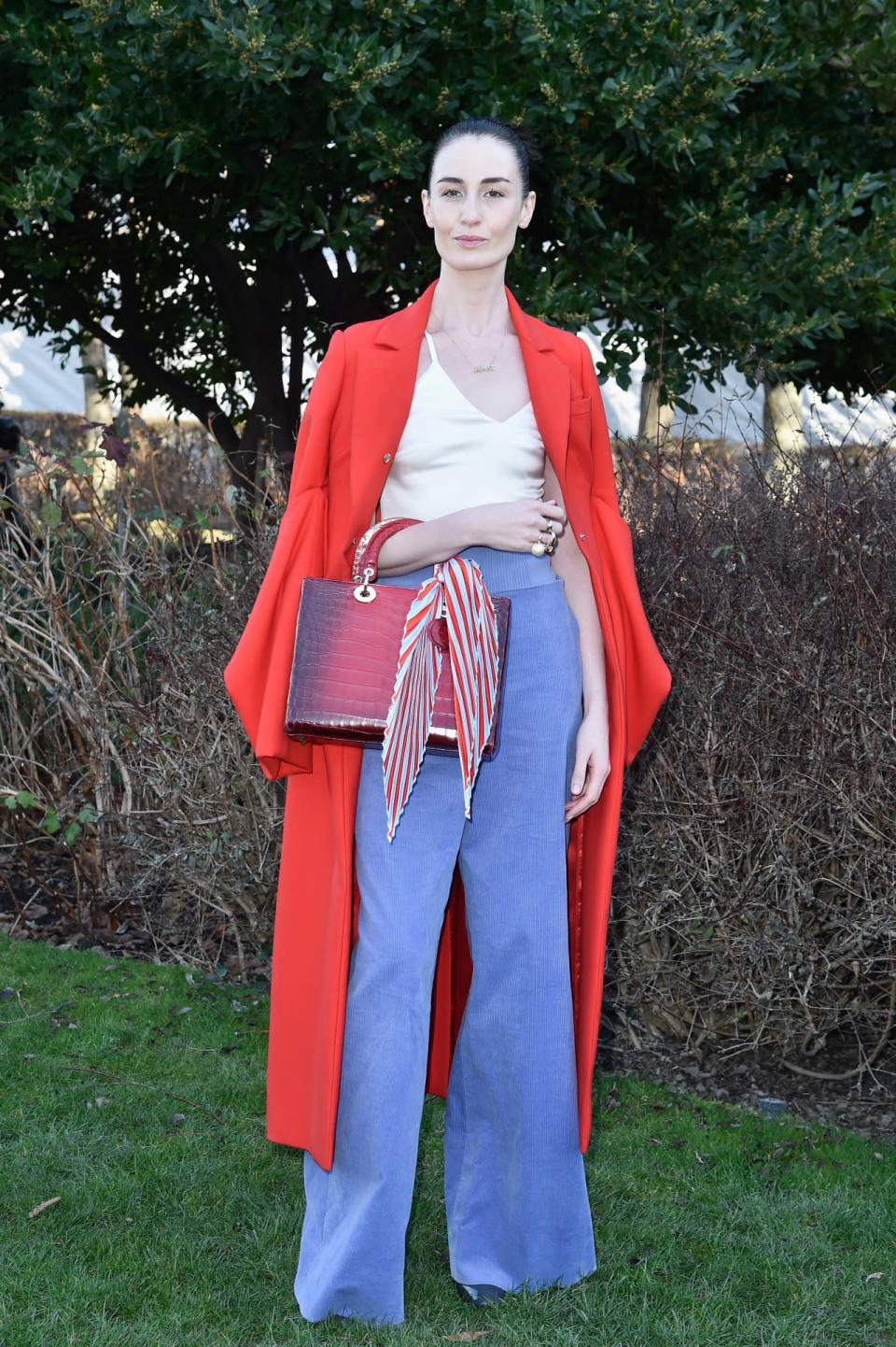 Erin O’Connor in blue flared pants and a red coat at the Dior spring/summer 2016 haute couture show in Paris.