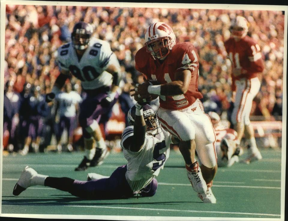 Terrell Fletcher breaks from the grasp of Northwestern's Dwight Brown to score one of his three touchdowns in a 1993 game.