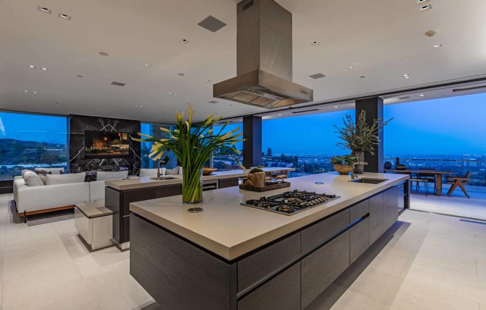 Sleek floor-to-ceiling glass walls offer views of the Los Angeles skyline.