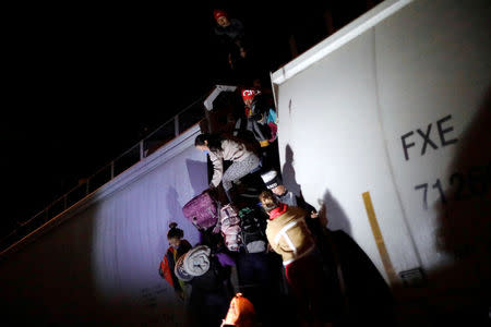 Central American migrants, moving in a caravan through Mexico, climb up on a wagon of a freight train before embarking on a new leg of their travels, in Tlaquepaque, in Jalisco state, Mexico April 19, 2018. REUTERS/Edgard Garrido