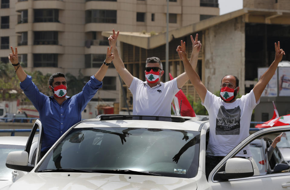 Anti-government protesters flash the victory sign during a driving convoy protest through the streets to express rejection of the political leadership they blame for the economic and financial crisis, in Beirut, Lebanon, Tuesday, April 21, 2020. On Tuesday Lebanon's parliament began a three-day legislative session at a Beirut theater so that legislators can observe coronavirus social distancing measures, as protests against the country's ruling elite in the crisis-hit country resumed. (AP Photo/Hussein Malla)