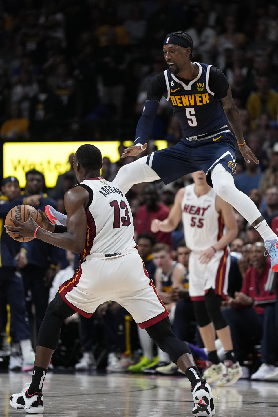 Miami Heat center Bam Adebayo (13) looks to pass while defended by Denver Nuggets guard Kentavious Caldwell-Pope (5) during the second half of Game 2 of basketball's NBA Finals, Sunday, June 4, 2023, in Denver. (AP Photo/Mark J. Terrill)