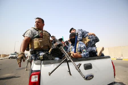 Iraqi policemen ride in a vehicle during a protest at the main entrance to the giant Zubair oilfield near Basra, Iraq July 17, 2018. REUTERS/Essam al-Sudani