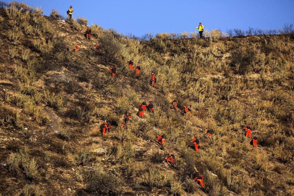 Hand crews work on the remaining hot spots from the Apple Fire near Banning, Calif., Sunday, Aug. 2, 2020. (AP Photo/Ringo H.W. Chiu)