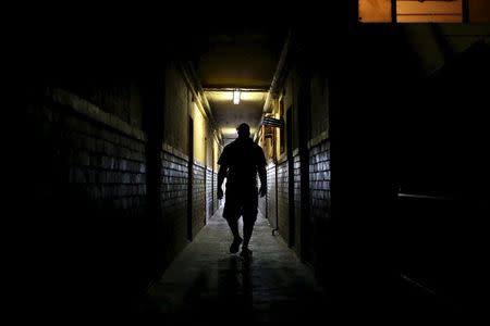 A man walks in a passage at Jeppestown men's hostel in Johannesburg May 19, 2015. REUTERS/Siphiwe Sibeko