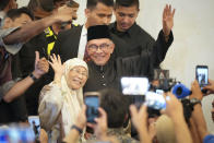 Malaysia's newly appointed Prime Minister Anwar Ibrahim and his wife Wan Azizah waves as they arrive at a gathering in Kuala Lumpur, Malaysia, Thursday, Nov. 24, 2022. Malaysia's king on Thursday named Anwar as the country's prime minister, ending days of uncertainty after the divisive general election produced a hung Parliament. (AP Photo/Vincent Thian)