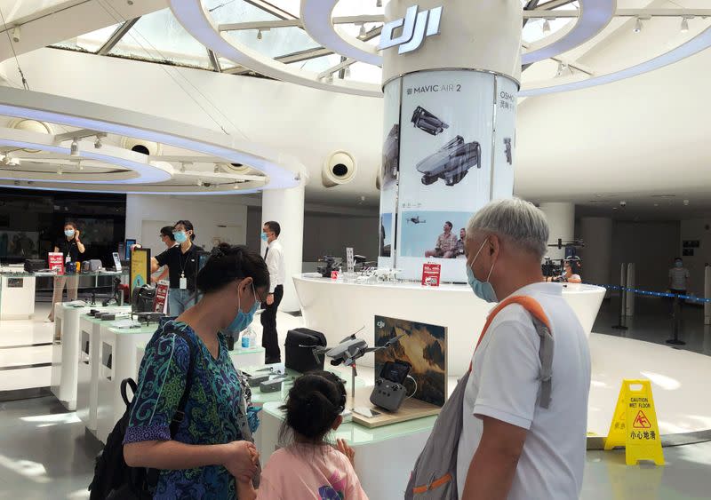 People wearing face masks following the coronavirus disease (COVID-19) outbreak shop at a DJI's flagship store in Shenzhen