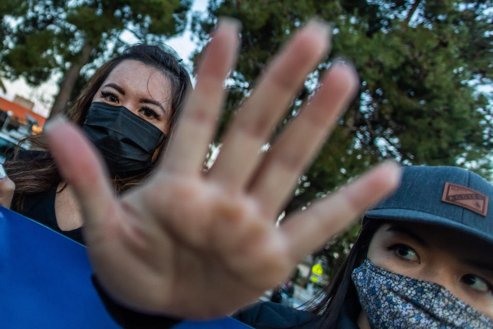 Clover and Julie Tran stand with outstretched hands during a candlelight vigil in Garden Grove, California, on March 17, 2021, to unite against the recent spate of violence targeting Asians. (Photo: APU GOMES via Getty Images)