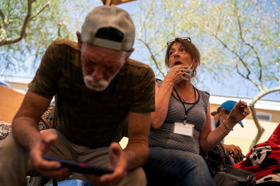 David (left) and his partner Vicky Alspaugh (right) sit in a shaded area at Human Services Campus on Saturday, June 4, 2022, in Phoenix. The center has a number of shaded areas to mitigate the dangers of prolonged sun exposure for unhoused residents, especially during the summer.