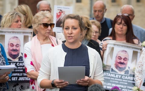 Bridget Reeves (centre), the granddaugher of Elsie Devine who died at Gosport War Memorial Hospital, and the families of other victims speak to the media outside Portsmouth Cathedral - Credit: Dominic Lipinski /PA