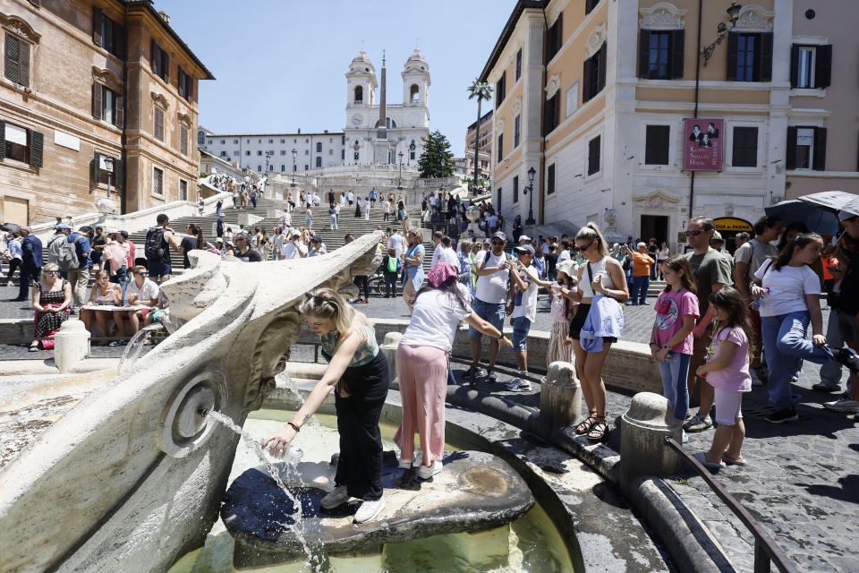 Tourists line up to fill their water bottles and cool off at the Barcaccia fountain beneath the Spanish Steps in downtown Rome, Thursday, July 11, 2024. (Cecilia Fabiano/LaPresse via AP)