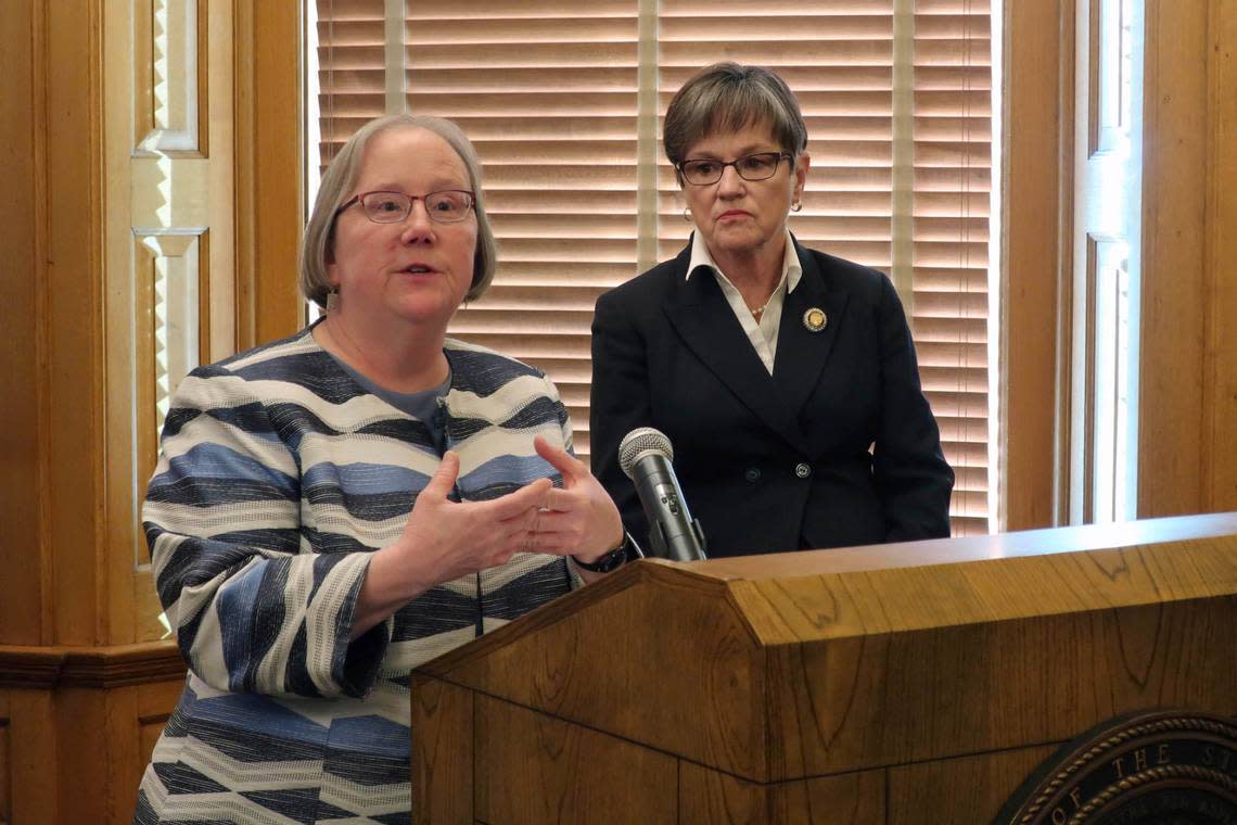 Laura Howard, left, the top social services administrator in Kansas state government, discusses a plan to merge two agencies as Gov. Laura Kelly, right, watches, during a news conference, Wednesday, Jan. 8, 2020, at the Statehouse in Topeka.