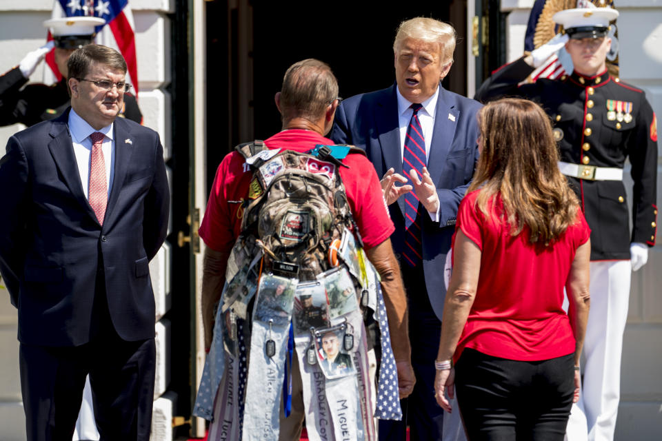 President Donald Trump, accompanied by Veterans Affairs Secretary Robert Wilkie, left, and Karen Pence, the wife of Vice President Mike Pence, right, greets Terry Sharpe, center, known as the "Walking Marine" at the White House in Washington, Monday, July 27, 2020. Sharpe has walked from Summerfield, N.C., to Washington to raise awareness of the current veteran suicide rate. (AP Photo/Andrew Harnik)