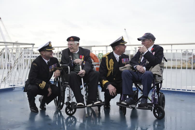 Les vétérans britanniques de Normandie Jim Grant, deuxième à gauche, et Charles Horn posent avec des membres de la Royal Navy le 4 juin 2024