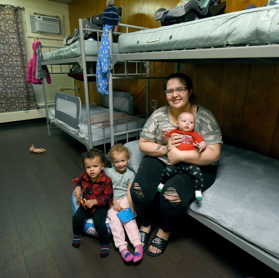 Romy Kelley, 24, of Monroe, with her three children, son Daylen Daykin, 2, daughter Violet Daykin, 3, and three-month-old son Rylo Daykin sit in their room at the Oaks Shelter in Monroe. The mother and children arrived at the shelter on November 3, 2022, which provides transitional housing and an emergency warming shelter for the homeless.