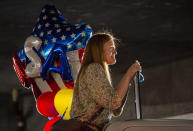 In this Sunday, March 22, 2020 photo, Gina Hardy from Beaver, Utah, looks for her son Elder Ethan Hardy, as he returns from his mission to the Philippines, at the Salt Lake City International Airport. Sen. Mitt Romney and Utah state leaders are criticizing a large gathering of family and friends who went to the Salt Lake City airport to welcome home missionaries when people are supposed to be keeping their distance from one another to prevent more spread of the coronavirus. (Rick Egan/The Salt Lake Tribune via AP)