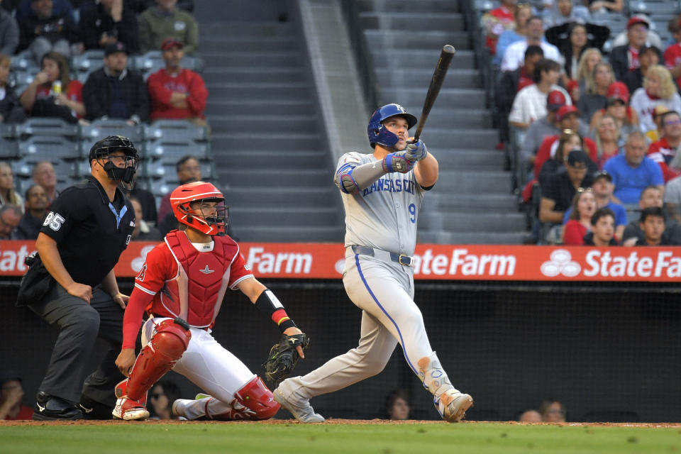 Kansas City Royals' Vinnie Pasquantino, right, hits a two-run home run as Los Angeles Angels catcher Logan O'Hoppe, center, watches along with home plate umpire Stu Scheurwater during the third inning of a baseball game Thursday, May 9, 2024, in Anaheim, Calif. (AP Photo/Mark J. Terrill)