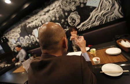 Shiro Fukai (front), 48, drinks distilled spirit at the Otasuke "izakaya" style pub and restaurant in Tokyo May 8, 2014. REUTERS/Toru Hanai