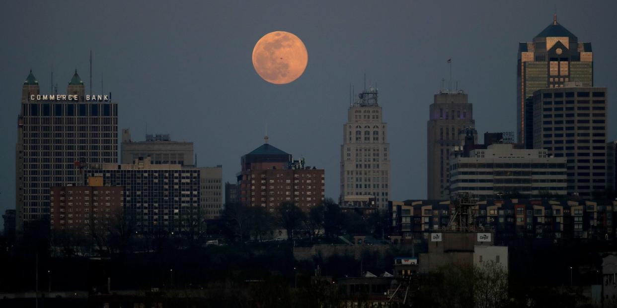 Ein Supermond geht hinter einem Bürogebäude in der Innenstadt von Kansas City, Missouri, auf. - Copyright: Charlie Riedel/AP