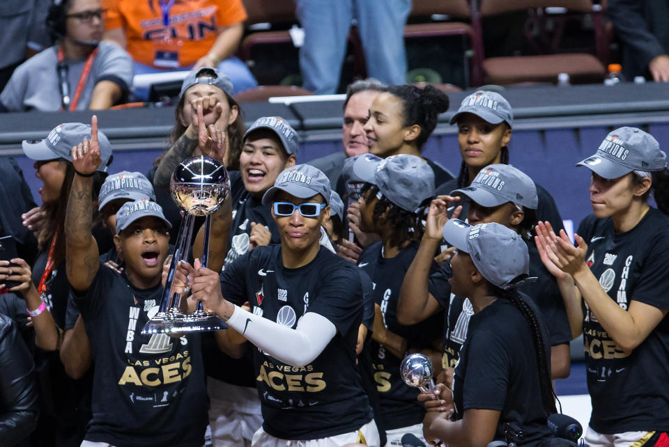 Las Vegas Aces forward A&#39;ja Wilson hoists the 2022 WNBA championship trophy surrounded by her teammates. (M. Anthony Nesmith/Icon Sportswire via Getty Images)