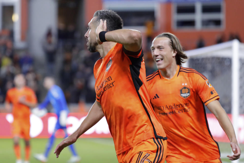 Houston Dynamo midfielder Hector Herrera, center, puts his hand to his ear as he runs with midfielder Griffin Dorsey, right, after Herrera scored a goal on a pass from Dorsey against Austin FC during the second half of an MLS soccer match Saturday, March 18, 2023, in Houston. (AP Photo/Michael Wyke)