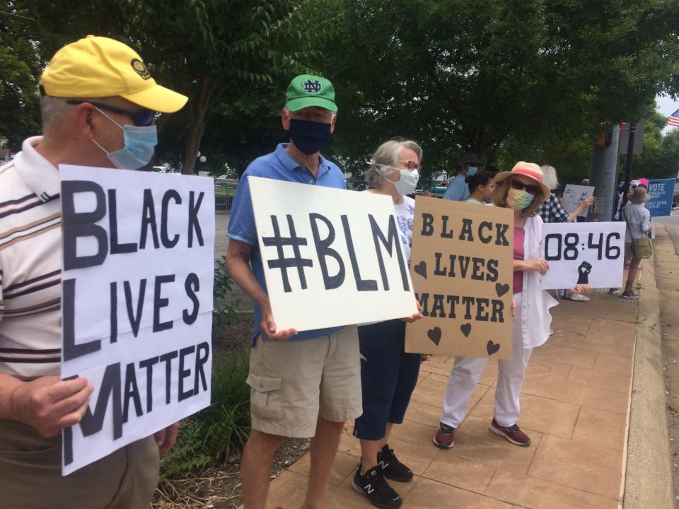 Jim Brooks, left, donning a mask amid the coronavirus outbreak and holding onto a “Black Lives Matter” sign, said he was there to “stand up for what is right” and join others in expressing concerns.