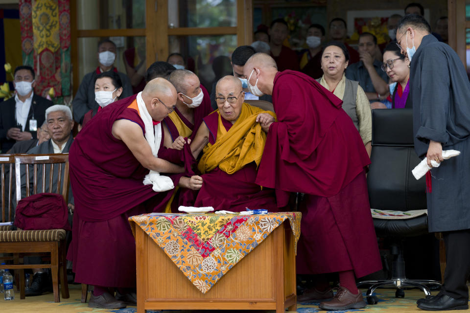 Tibetan spiritual leader the Dalai Lama is helped by attendant monks as he gets up from his chair during a function marking his 88th birthday at the Tsuglakhang temple in Dharamshala, India, Thursday, July 6, 2023. (AP Photo/Ashwini Bhatia)
