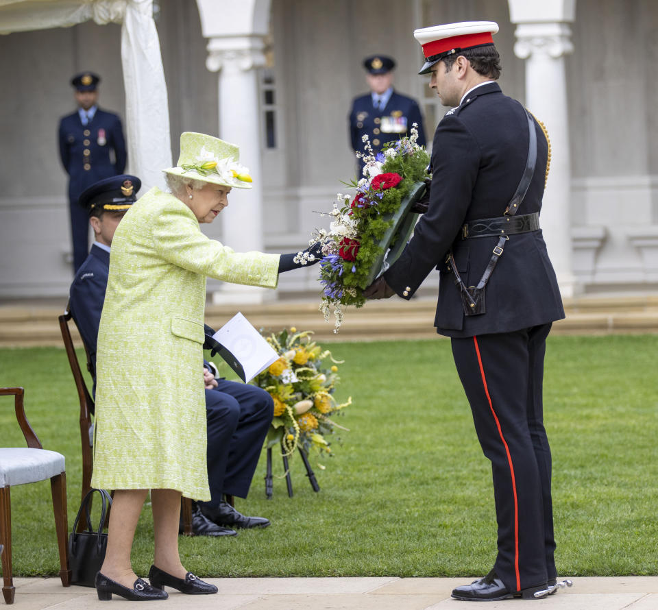 Queen Elizabeth II inspects a wreath before it was laid by her equerry for her. (PA Images)