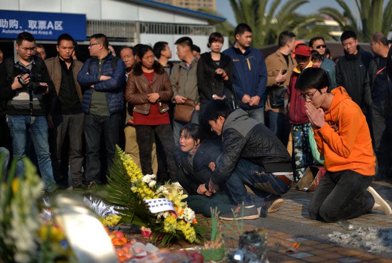 Relatives mourn for the victims of a terror attack that killed 31 people at the main train station in Kunming, southwest China's Yunnan province, March 7, 2014