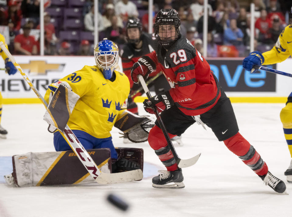 Canada forward Marie-Philip Poulin (29) and Sweden goaltender Emma Soderberg (30) watch the puck during the second period of a quarterfinal match at the women's world hockey championships in Brampton, Ontario, Thursday, April 13, 2023. (Frank Gunn/The Canadian Press via AP)